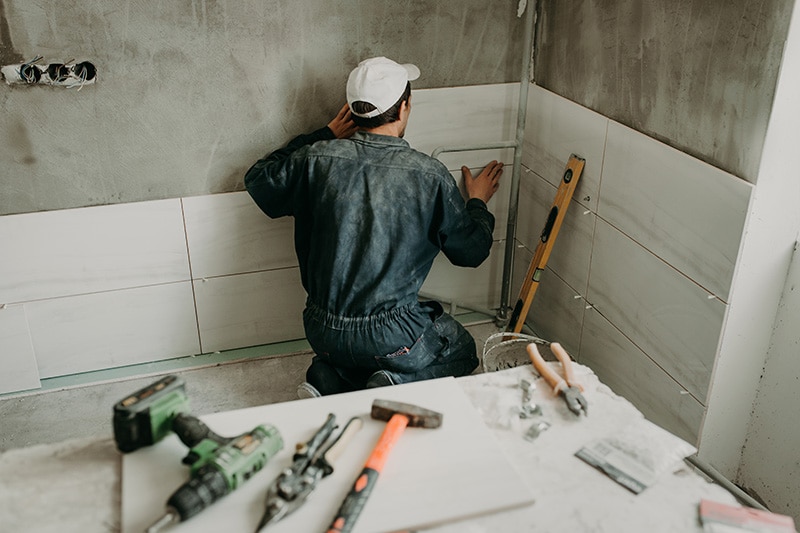worker repairman puts large ceramic tiles